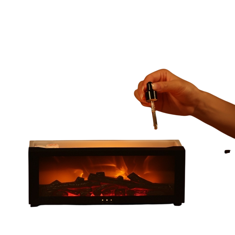 A black electric fireplace insert with glowing orange and red faux logs, shown against a white background with a hand holding a small accessory above it.
